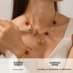Detail of vintage gold-plated necklace set featuring tiger eye sun and heart pendants
