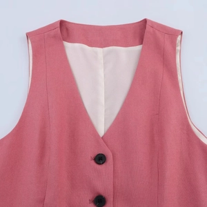 Detail of pink linen blend vest featuring V-neckline and dark buttons on white background