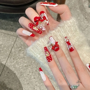 Handmade Christmas press-on nails featuring red bows, snowflakes, and festive 3D gems