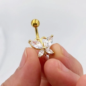 Golden butterfly belly button ring with sparkling zircon stones in a close-up hand shot