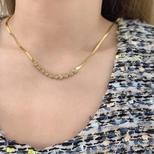 Golden titanium steel snake bone chain necklace with round zircon pendant on model