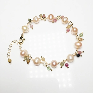 Detail of freshwater pearl bracelet with tourmaline and gold lobster clasp closure