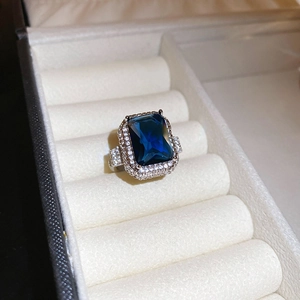 Macro view of luxury rectangle blue gemstone ring with micro-pave white cubic zirconia