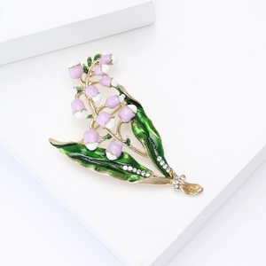 Detail of pink lily of the valley brooch with green enamel leaves and sparkling rhinestones