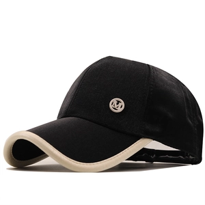Black satin baseball cap with beige brim piping and metal M logo on side view