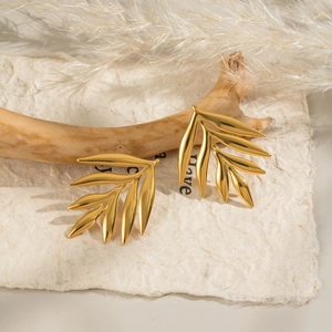 Nature-inspired golden leaf stud earrings in stainless steel on a rustic driftwood display