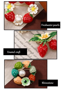 Detail of strawberry brooch featuring freshwater pearls, enamel craft, and rhinestones