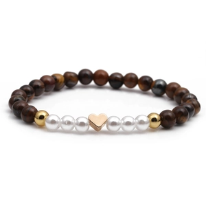 Bracelet en perles d'oeil de tigre avec un pendentif coeur or rose sur fond blanc