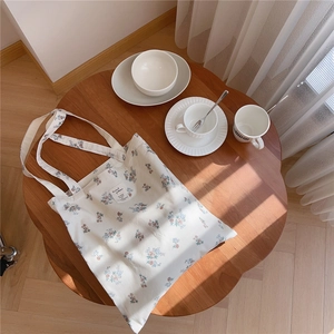Sac fourre-tout en coton fleuri sur table en bois avec une lumière naturelle douce