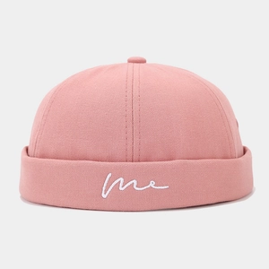 Detailed view of pink canvas docker hat with white embroidered me lettering and six-panel crown