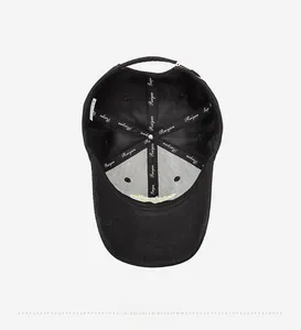 Detailed interior of a black cotton baseball cap showing branded inner seams and stitching
