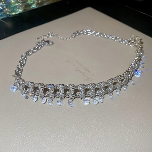 Close-up of sparkling zircon tassel necklace with silver mesh and lobster clasp