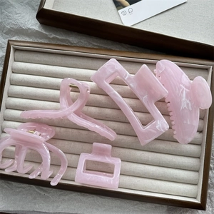Detailed set of five pink marble textured acetate hair claws in various elegant styles