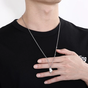 Irregular textured silver moon pendant necklace worn by male model on black t-shirt