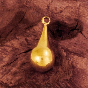 Macro shot of 3D gold teardrop pendant on rustic wood surface for DIY jewelry making