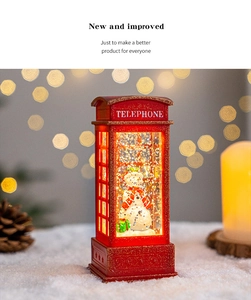 Detail shot of Christmas snow globe telephone box lantern with snowman and warm LED lights.