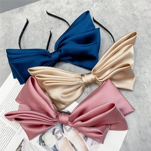 Three-layer satin bow headbands in navy, champagne, and pink with elegant glossy finish