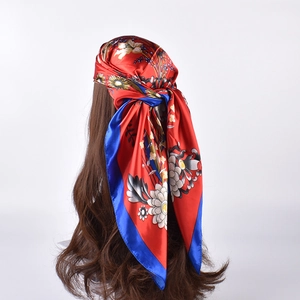 Floral print satin square scarf in red and royal blue tied as a stylish headscarf