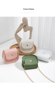 Detailed view of mini crossbody chain bags in pink, white, and green on a wooden display