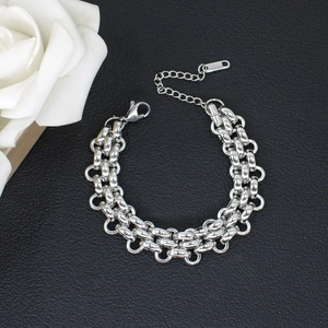 Detail of silver double-layered interwoven chain bracelet with lobster clasp and tag