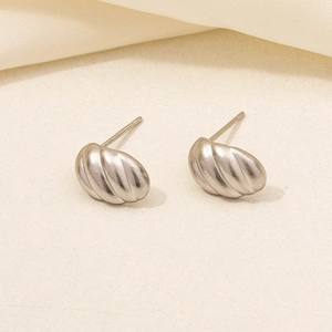 Close-up of silver wavy curved stud earrings with brushed 304 stainless steel texture