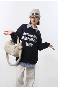 Detail of beige quilted nylon shoulder bag styled with an autumn streetwear outfit
