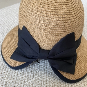 Detalle de sombrero de paja con elegante lazo de cinta negra y ala ancha ribeteada
