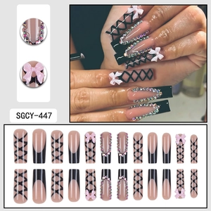 Long coffin press-on nails with black bow, ribbon lines and rhinestones over pink base