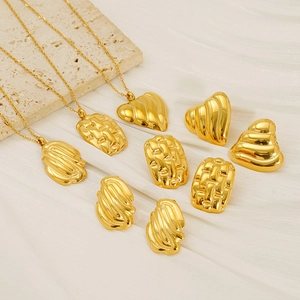 Flat lay of 18K gold plated stainless steel necklaces and textured geometric earrings
