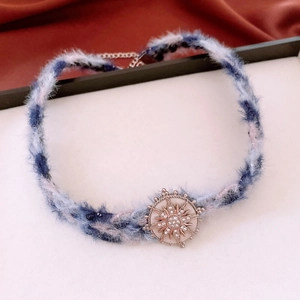 Gros plan du ras-du-cou en peluche avec pendentif étoile vintage orné de strass blancs