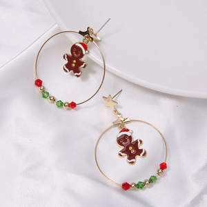 Detail view of Christmas earrings with gingerbread man charms and red green beads on silk