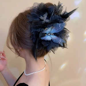 Detail of elegant hair claw with black mesh flowers, feathers, and rhinestone butterflies