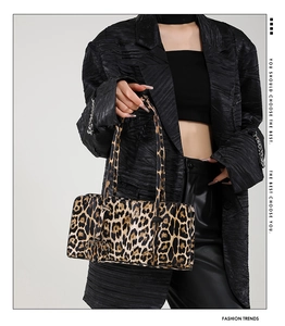 Macro shot of stylish leopard print baguette bag texture and slim carrying handle