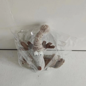 Detail einer Weihnachts-Rentier-Plüschpuppe mit Strickmütze in einem klaren Polybeutel