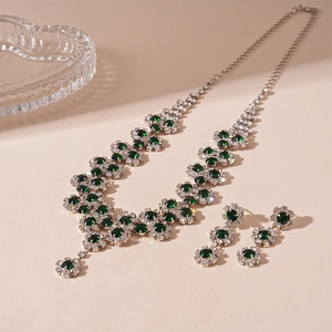 Detailed close-up of a silver vintage jewelry set featuring emerald green gemstones