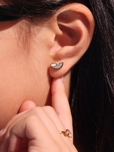 Gros plan d'un ensemble de boucles d'oreilles et bague nuage arc-en-ciel