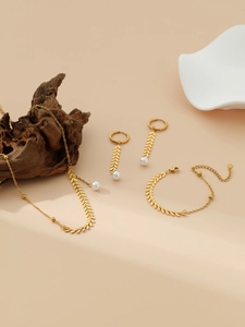 Détail d'un ensemble de bijoux feuilles de blé dorées et perles avec collier et boucles