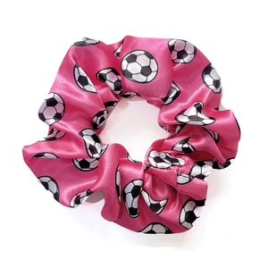 Detail shot of bright pink satin scrunchie with classic soccer ball pattern print