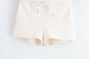 Detail of off-white casual shorts featuring drawstring waist and knit fabric texture