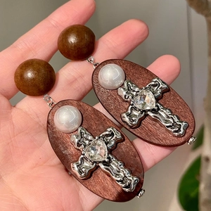 Vue détaillée des boucles d'oreilles vintage en bois avec croix et cristal en cœur
