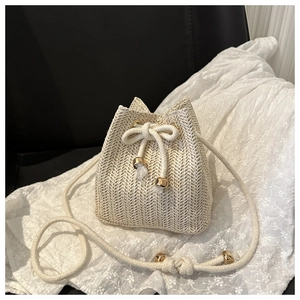 Detail of woven straw bucket bag with gold bead accents and elegant drawstring closure