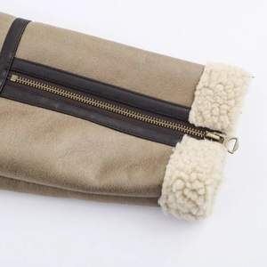 Detail of khaki leather jacket with brass zipper and cream fleece lining texture