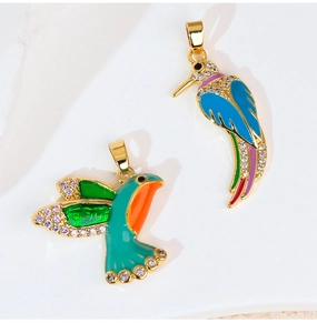 Detailed view of two hummingbird pendants with colorful enamel and cubic zirconia stones