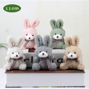 Group of 11cm plush rabbits in five colors with plaid bows on decorative books