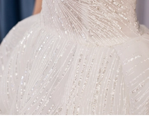 Macro shot of sparkling silver sequins on white bridal tulle with radiating patterns