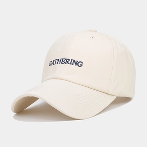 Détail de la broderie GATHERING bleu foncé sur une casquette en coton crème