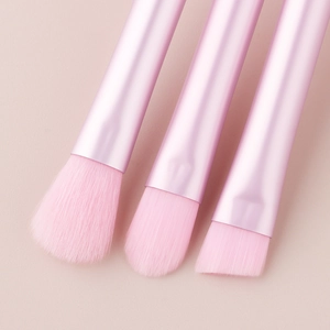 Macro shot of pink makeup brushes with soft synthetic bristles and metallic handles