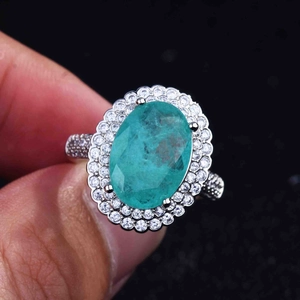 Macro shot of oval Paraiba tourmaline ring with double halo and micro-pave diamonds
