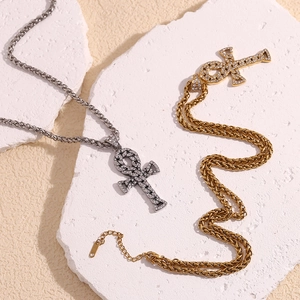 Detail view of gold and silver Ankh cross pendants with rhinestones on twist chains