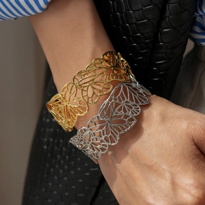 Vue détaillée des bracelets manchettes en métal doré et argenté avec motif papillon évidé